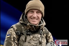 Портрет усміхненого українського захисника Олександра Максимчука на фоні прапора