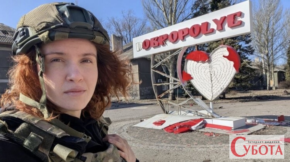 Мар'яна Безугла у військовому спорядженні біля стели Добропілля"