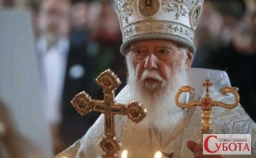 Патріарх Філарет з хрестом та жезлом під час богослужіння