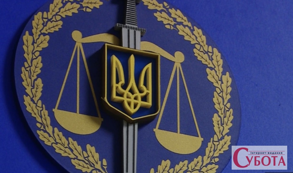 Офіційна емблема прокуратури України з терезами та мечем на синьому тлі, 2026 рік