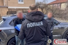 Поліцейський затримує підозрюваних у шахрайстві з продажем авто військовим на Одещині, 2026 рік