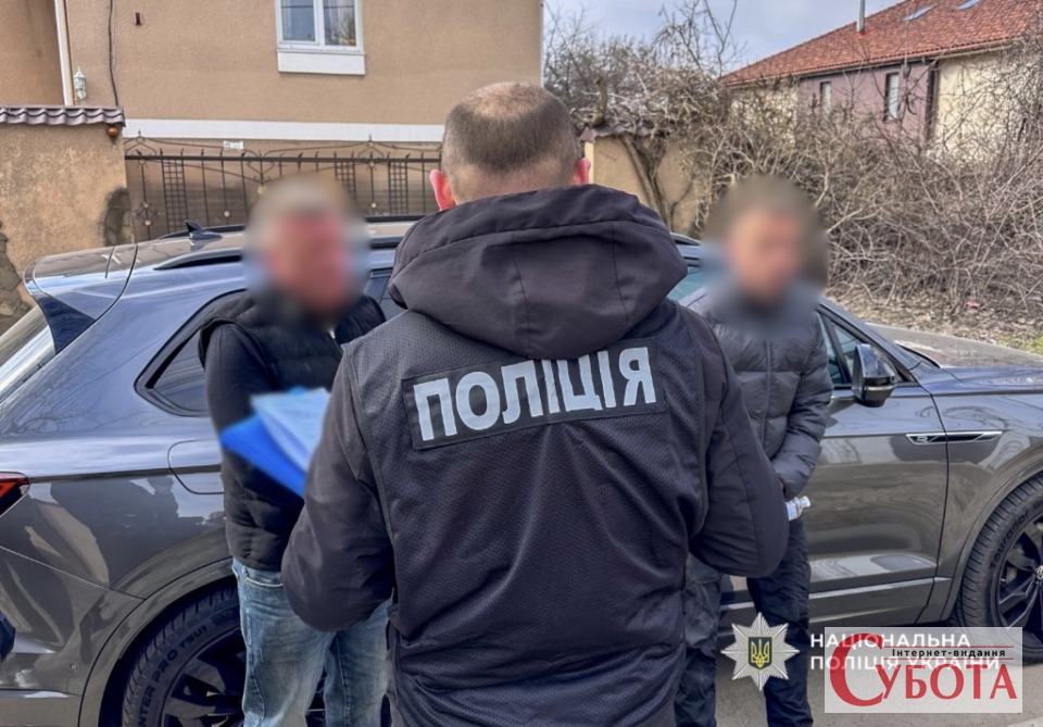 Поліцейський затримує підозрюваних у шахрайстві з продажем авто військовим на Одещині, 2026 рік