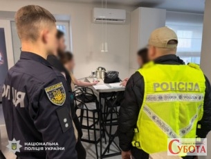 Український та латвійський поліцейські під час обшуку у квартирі шахраїв в Івано-Франківську