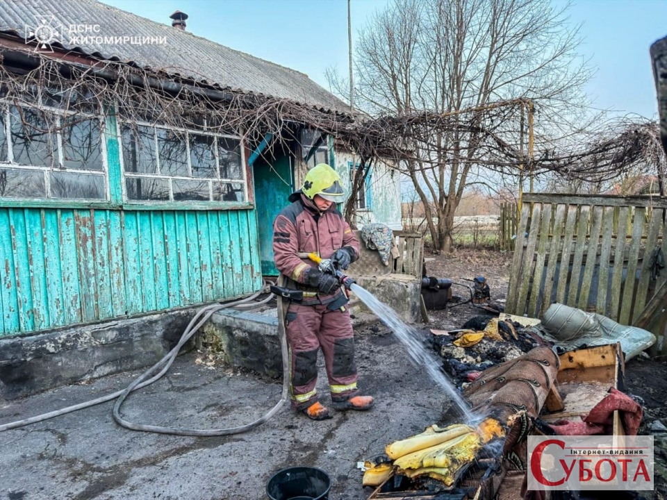 Рятувальник ДСНС гасить залишки речей після пожежі в селі Кодня