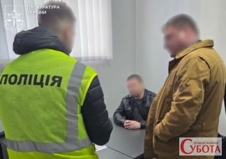 Співробітник поліції у зеленому жилеті спілкується з підозрюваним жителем Бердичева