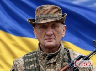 Захисник України, командир відділення Василь Прокопенко на тлі прапора