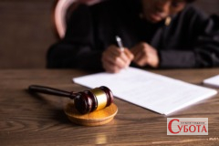 Суддя підписує документи у суді