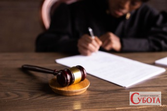 Суддя підписує документи у суді