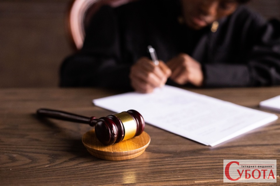 Суддя підписує документи у суді