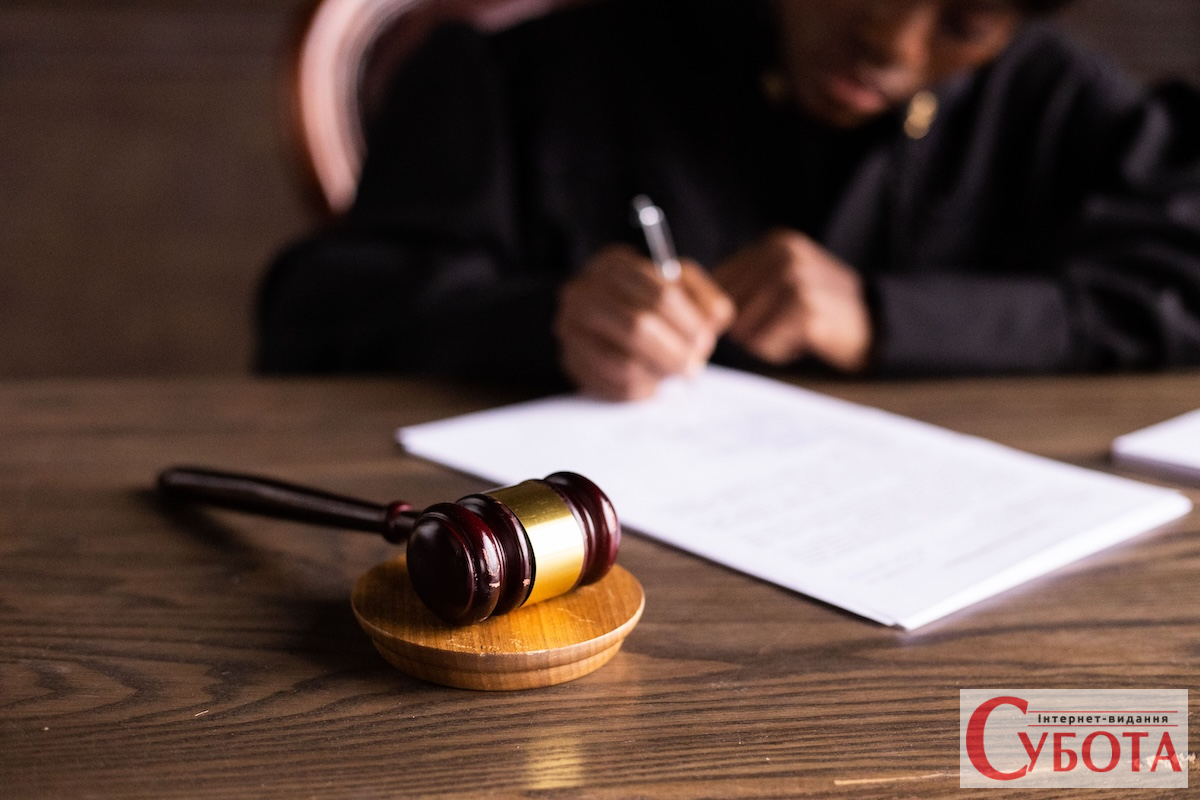 Суддя підписує документи у суді