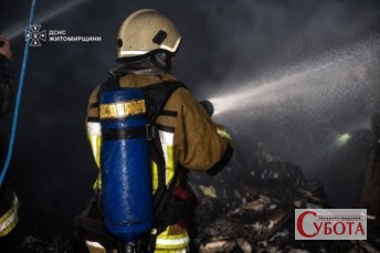 Рятувальник гасить пожежу після нічної атаки дронів на Житомирщину