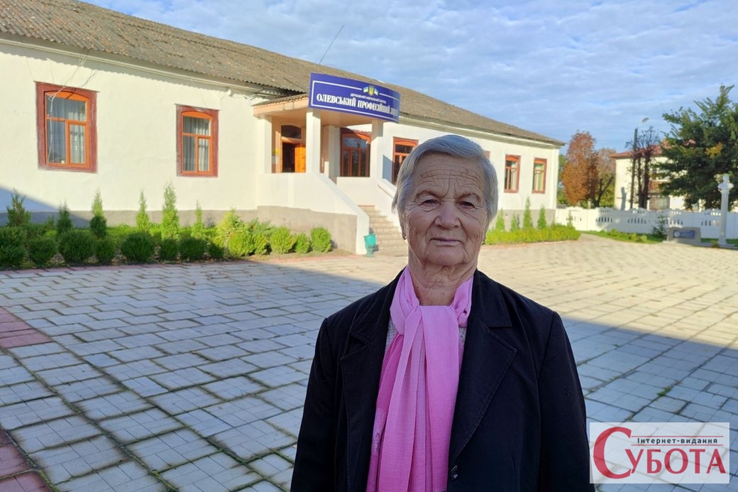 Катерина Денисюк біля будівлі колишнього ПТУ №10, куди вона прийшла навчатися 60 років тому. Олевськ